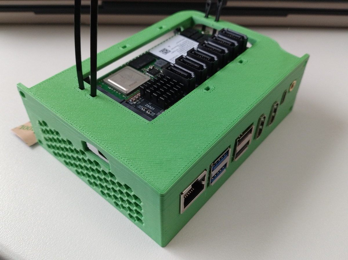 The backside of the SBC in the 3D-printed module, with tie wraps sticking out above a hole that both M2 units are visible through