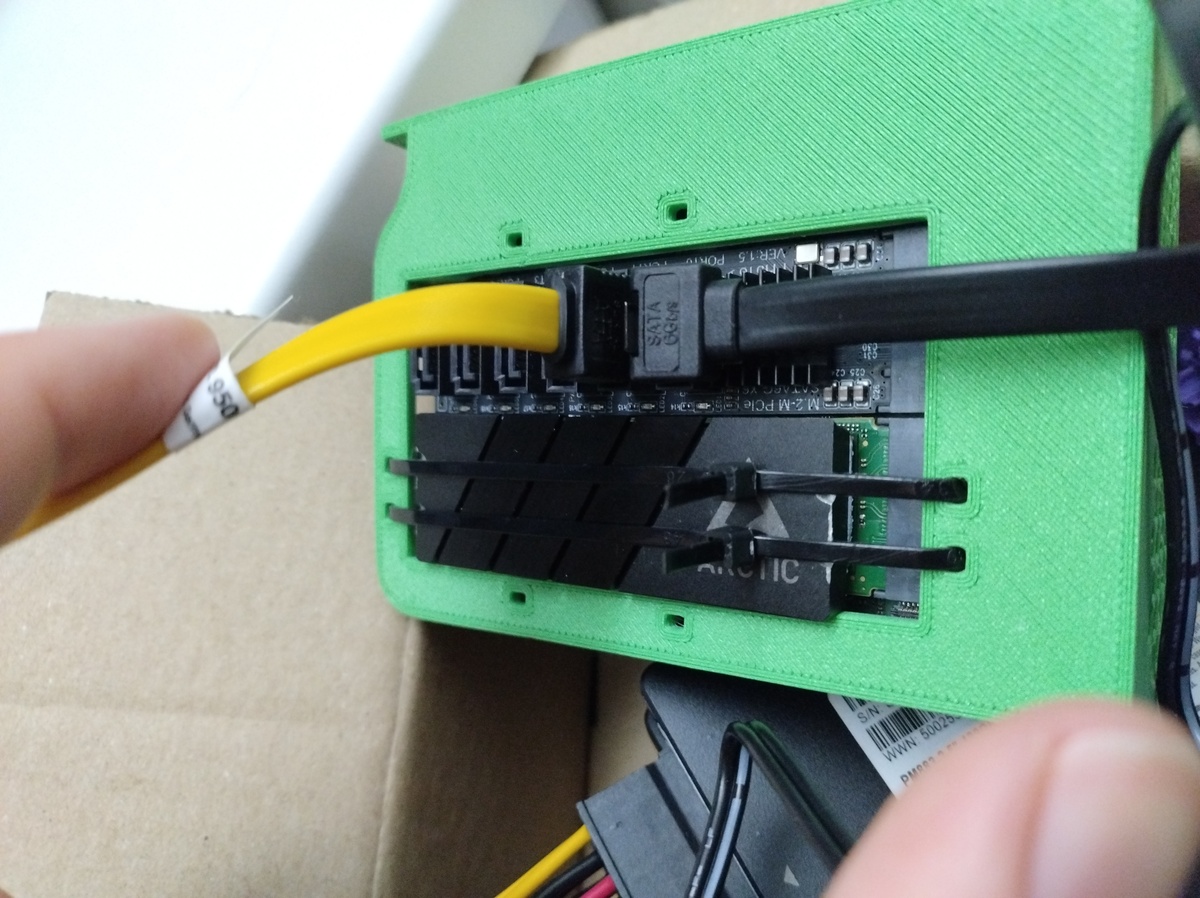 The backside of the SBC in the 3D-printed module, now with the heatsink for the NVMe SSD in place and the tie wraps tightened over it