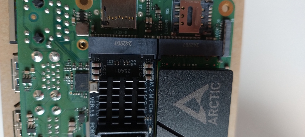 Picture of the 2 occupied M2 slots: one with an NVMe, one with a SATA adapter, showing there is much less than a millimeter of space between them
